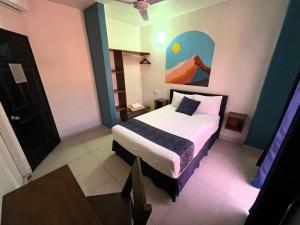 コリマにあるHotel Juarez 70のベッドと壁に絵が飾られた寝室