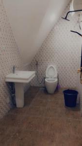 a bathroom with a sink and a toilet at Dazzle Hotels and Apartments in Jidu
