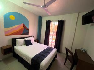 a bedroom with a bed and a ceiling fan at Hotel Juarez 70 in Colima