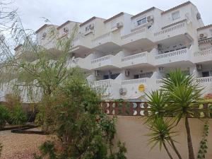een groot wit gebouw met bomen ervoor bij Paraiso Del Sol in Denia