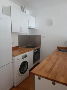 een keuken met een wasmachine en een houten aanrecht bij Paraiso Del Sol in Denia