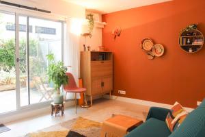 een woonkamer met oranje muren en een blauwe bank bij Studio with terrace near Paris in Boulogne-Billancourt