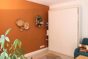 een kamer met een oranje muur en een grote witte deur bij Studio with terrace near Paris in Boulogne-Billancourt