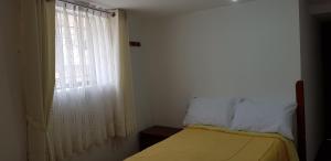 Oro Verde Hostal في كوسكو: غرفة نوم صغيرة بها سرير ونافذة