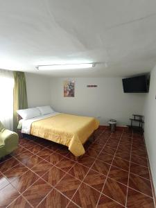 ein Schlafzimmer mit einem Bett und Fliesenboden in der Unterkunft Oro Verde Hostal in Cusco