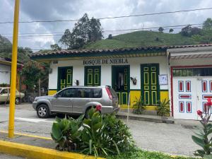 a car parked in front of a building at BOSQUE DE NIEBLA in Pijao