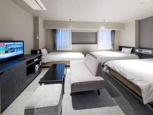 a hotel room with two beds and a flat screen tv at New Osaka Hotel in Osaka