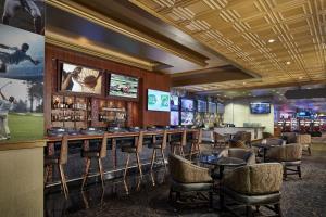 un bar con sillas, mesas y TV en Horseshoe Tunica Casino & Hotel, en Robinsonville
