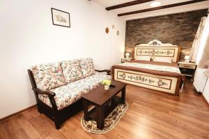 a bedroom with a bed and a couch and a table at The Transylvanian Apartment - near Bridge ofLies in Sibiu +23 photos