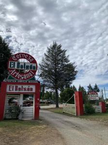 a sign for a gas station on a dirt road at Camping El Bolson in El Bolsón