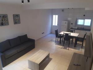a living room with a couch and a table with chairs at Dúplex Complejo Condarco in Guaymallen