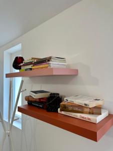 a stack of books sitting on a shelf at Cocon tout confort à 25 min de Paris in Sevran
