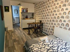 a bedroom with a bed and a kitchen with a table at Urban Loft Studio #1 in London