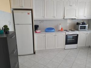a kitchen with white cabinets and a white refrigerator at Vens apartment 90m2 at Eantio bay. in Aiándion