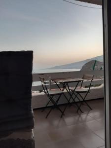 un tavolo e sedie su un balcone con vista sull'oceano di Vistas al mar y a la montaña a Tabaiba