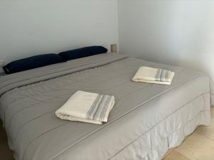 ein weißes Bett mit zwei Handtüchern darüber in der Unterkunft Vistas al mar y a la montaña in Tabaiba