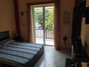 sypialnia z łóżkiem i przesuwnymi szklanymi drzwiami w obiekcie Vens apartment 90m2 at Eantio bay. w mieście Aiándion