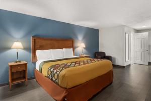 a bedroom with a bed and a blue wall at Americas Best Value Inn Carlisle in Carlisle