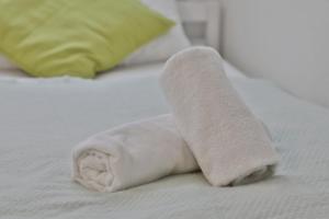 toalla enrollada encima de la cama en Moderne Ferienwohnungen - Service wie im Hotel, en Göppingen