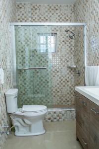 a bathroom with a toilet and a glass shower at Christal Sunshine in Boca Pen
