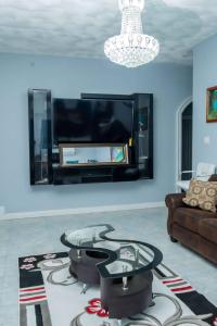 een woonkamer met een tv en een glazen tafel bij Christal Sunshine in Boca Pen
