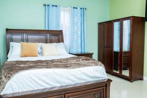 een slaapkamer met een groot bed en een dressoir bij Christal Sunshine in Boca Pen