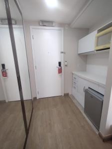 an empty kitchen with a white door and a counter at UH 1116 Flat Live Logde Vila Mariana in Sao Paulo