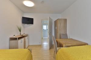 a room with two beds and a table and a dining room at Moderne Ferienwohnungen - Service wie im Hotel in Göppingen