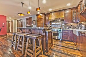 a kitchen with wooden cabinets and a bar with stools at Year Round Recreation Luxury Resort Amenities and Hot Tub Access! Deer Valley Arrowleaf 211 in Park City