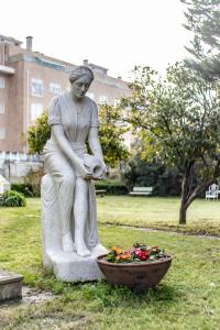 uma estátua de uma mulher sentada ao lado de uma taça de flores em Espinho Vintage - Alojamento de Charme em Espinho