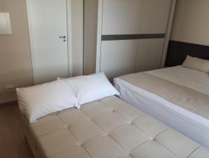 a small room with two beds with white sheets at UH 1116 Flat Live Logde Vila Mariana in Sao Paulo