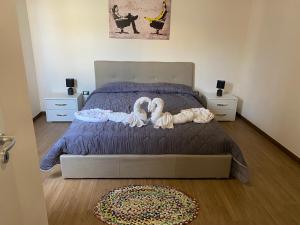 ein Schlafzimmer mit einem Bett mit zwei Schwänen darauf in der Unterkunft Da Maria Casa Vacanze in Marsala