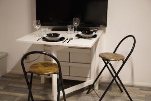 een kleine witte tafel met 2 stoelen en wijnglazen bij Zen Den Studio #2 in Londen