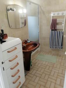 ein Badezimmer mit einem hölzernen Waschbecken und einem Spiegel in der Unterkunft Ker Loïc, Les Dunes, La Mer in Saint-Pabu