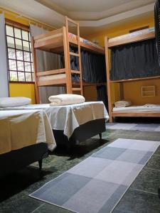 a room with two beds and two bunk beds at Village Hostel in Petrópolis