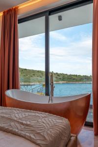 uma banheira num quarto com uma janela em Siro Kerma Private Beach Villa em Sarandë