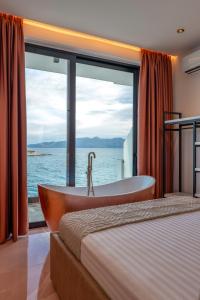 1 dormitorio con bañera y vistas al océano en Siro Kerma Private Beach Villa en Sarandë