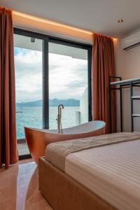 um quarto com uma banheira, uma cama e uma janela em Siro Kerma Private Beach Villa em Sarandë mais 37 fotografias