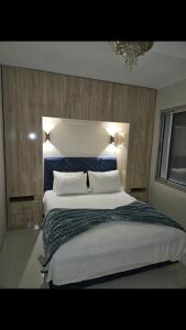 a bedroom with a large bed with a blue headboard at Appartement de haut standing in Tama ou Ennza