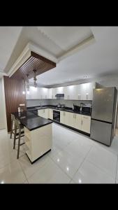 a large kitchen with white cabinets and a black counter top at Appartement de haut standing in Tama ou Ennza