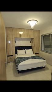 a bedroom with a large bed and a chandelier at Appartement de haut standing in Tama ou Ennza