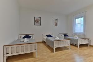 a room with three beds and a couch and a table at Studio Suite mit Service wie im Hotel in Göppingen