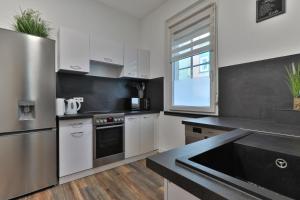a kitchen with white cabinets and a stainless steel refrigerator at Studio Suite mit Service wie im Hotel in Göppingen