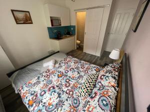 a small bedroom with a bed with a flowered blanket at City Nest Studio #3 in London