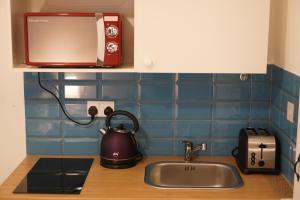 a kitchen counter with a sink and a microwave at City Nest Studio #3 in London