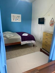 a blue bedroom with a bed and a dresser at SUITES Recanto do DO Mar in Saquarema