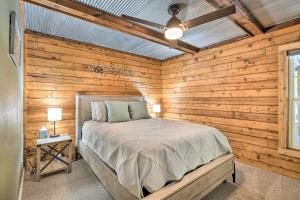 - une chambre avec un lit et un mur en bois dans l'établissement Secluded Table Rock LakeandBranson Cabin with Hot Tub!, à Kimberling City