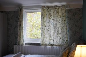 Exquisite Studio #4 في لندن: غرفة نوم مع نافذة مع ستائر وسرير