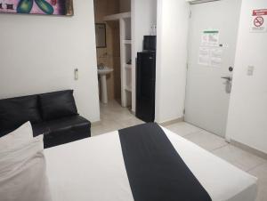 um quarto com uma cama, um sofá e uma porta em Loft Hotel Malecón Vallarta em Puerto Vallarta