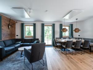 a living room with a couch and a table and chairs at Haus Elau in Donnersbachwald